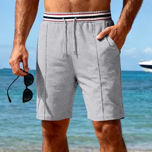 Gros plan sur un short de sport gris séchage rapide avec taille élastique rayée et cordon