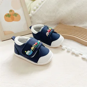 Detail of navy baby walking shoes with colorful cartoon vehicle decorations