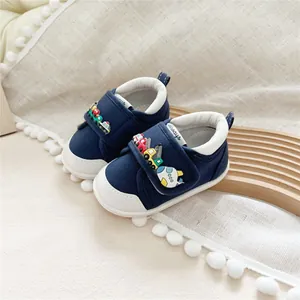 Close-up of navy blue baby walking shoes with colorful 3D cartoon vehicle decorations