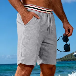 Détail gros plan du short de sport gris en maille gaufrée pour homme avec taille rayée.