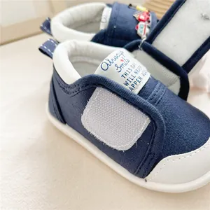 Close-up detail of navy blue baby soft-sole walking shoes with velcro strap