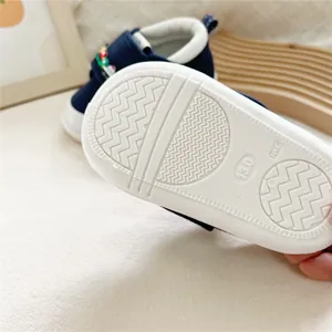 Detail view of the soft white anti-slip rubber sole on a navy baby walker shoe