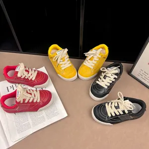 Selection of retro children's casual sneakers in red, yellow, and black leather textures.