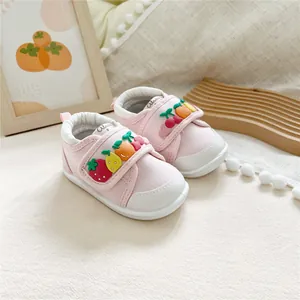 Close-up of pink baby walking shoes with cute fruit decorations and soft soles