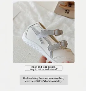 Gros plan d'une chaussure Mary Jane blanche pour enfant avec brides velcro grises.
