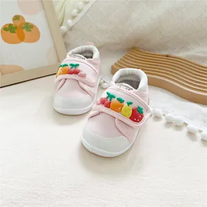 Close-up of pink baby toddler shoes featuring cute 3D fruit decorations
