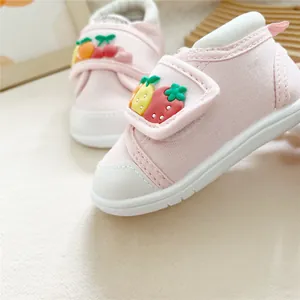 Close-up of pink baby walking shoes with cute 3D fruit decorations and velcro
