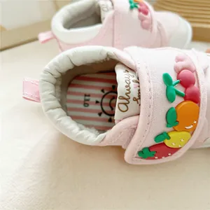 Detailed macro view of pink baby soft sole walking shoes with 3D fruit patterns
