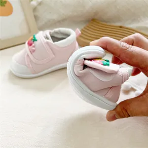 Close-up showing the soft and flexible sole of pink strawberry baby walking shoes