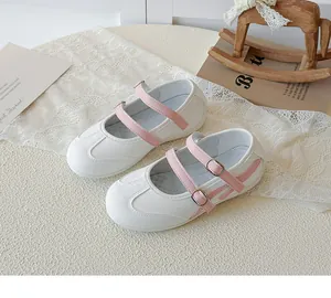 Gros plan sur les chaussures Mary Jane blanches pour enfants avec brides roses et mesh.