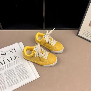 Macro detailed view of yellow vintage children's sneakers on a fashion magazine background
