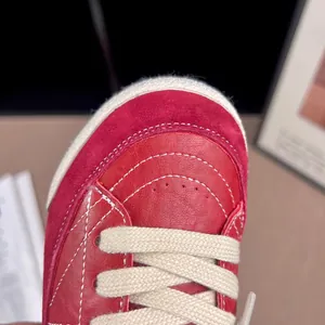 Close-up view of red children's retro sneakers showing leather texture and white stitching