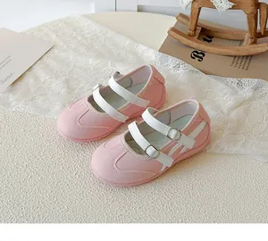 Gros plan de chaussures Mary Jane roses et blanches pour enfants avec doubles brides.
