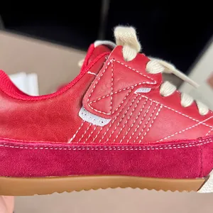 Close-up of red leather children's sneaker with white stitching and velcro strap