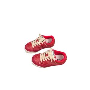 Vintage style red children's sneakers with cream laces shown on a white background
