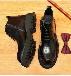 Top down view of black leather men's Martin boots with thick lug soles and a burgundy bowtie