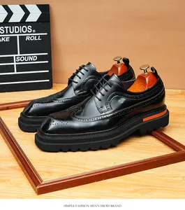 Detailed view of men's black glossy leather brogue shoes with stylish thick platform soles