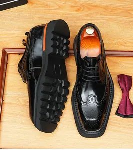 Close-up detail of black patent leather wingtip brogue shoes with thick lug soles