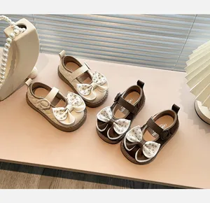 Elegant girls' Mary Jane shoes with quilted texture and large floral bows in cream and brown