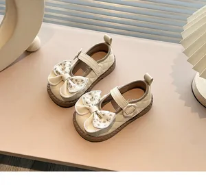 Detail view of beige quilted girls' Mary Jane shoes featuring a floral pattern bow