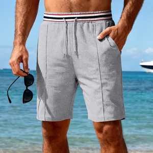 Macro view of men's quick-dry grey sports shorts featuring a striped elastic waistband.