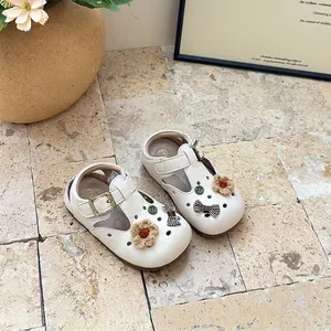 Macro detail view of cream toddler girl Mary Jane shoes with floral and bow charms
