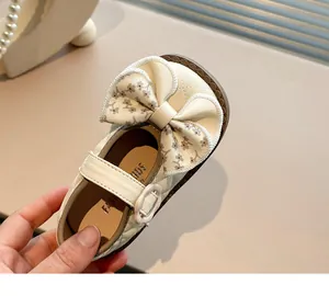 Detailed view of cream Mary Jane shoe for girls with floral bow and quilted texture.