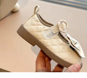 Detailed view of cream quilted Mary Jane shoes for girls with a flower buckle and bow