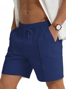 Dettaglio di pantaloncini in lino blu navy con coulisse in vita e cuciture verticali.