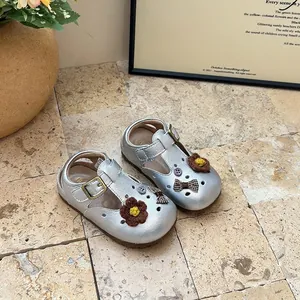 Close-up of silver toddler T-strap shoes with cute knit flowers and bow accents