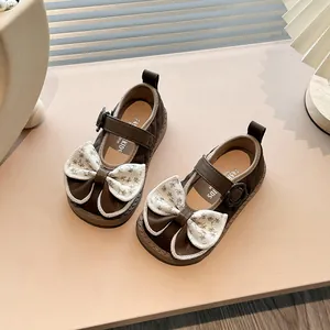 Elegant brown girls' Mary Jane shoes featuring a decorative floral bow and soft anti-slip sole