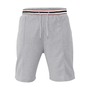Close-up of grey athletic shorts featuring a striped elastic waistband and drawstring.