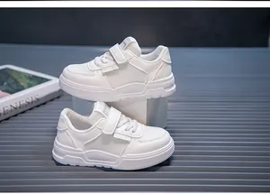 Detailed macro view of white children's sports shoes featuring soft soles and velcro straps.