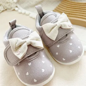 Detailed view of grey toddler girl walking shoes with white heart print and bow detail