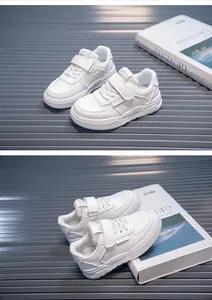 Detailed close-up view of white children's sneakers featuring velcro straps and soft sole