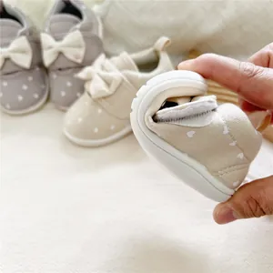Flexible soft sole demonstration on toddler girls' canvas bow walking shoes.