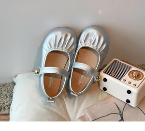 Close-up of silver girls Mary Jane shoes with pleated design and soft sole
