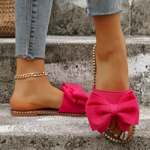 Detalle de sandalias planas rosas con lazo elegante para mujer en tela muy suave
