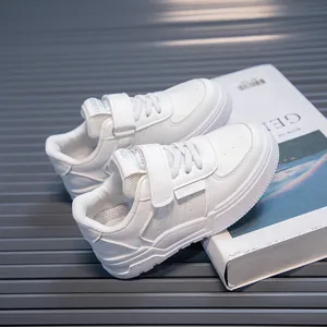 Close-up of white children's sports sneakers with velcro straps and soft thick soles.