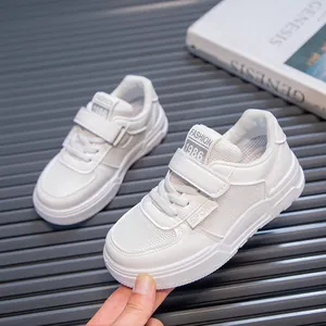 Detail view of white children's sneakers with breathable mesh and velcro strap