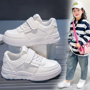Detailed side view and lifestyle shot of kids' white sports sneakers with velcro straps.