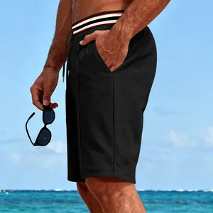 Detail view of black quick-dry sports shorts with striped waistband and mesh texture