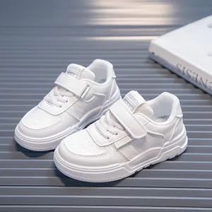 Detail view of white children's casual sneakers with velcro straps and soft soles.