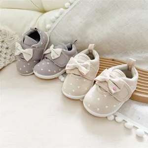 Adorable infant girls' soft sole walking shoes featuring bow ties and white heart patterns