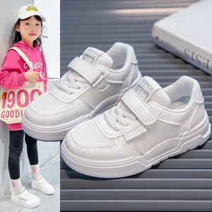 Detailed view of white children's sports sneakers with velcro and mesh upper
