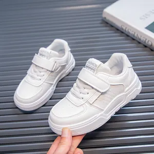 Close-up of white children's casual sneakers featuring a hook-and-loop strap and soft sole