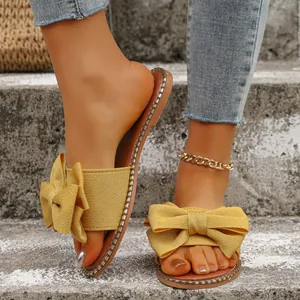 Primer plano de sandalias planas amarillas de tela con lazo decorativo en escalones