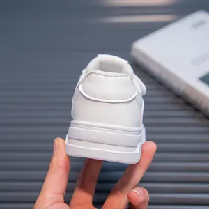 Detailed rear view of minimalist white casual sneakers for kids featuring soft sole
