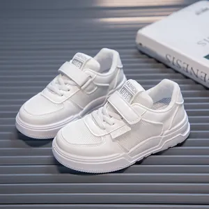 Detailed view of white children's sports shoes with velcro straps and mesh panels.