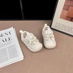 Detailansicht cremefarbener Mädchen-Sneaker mit eleganten Schleifen- und Perlenakzenten.